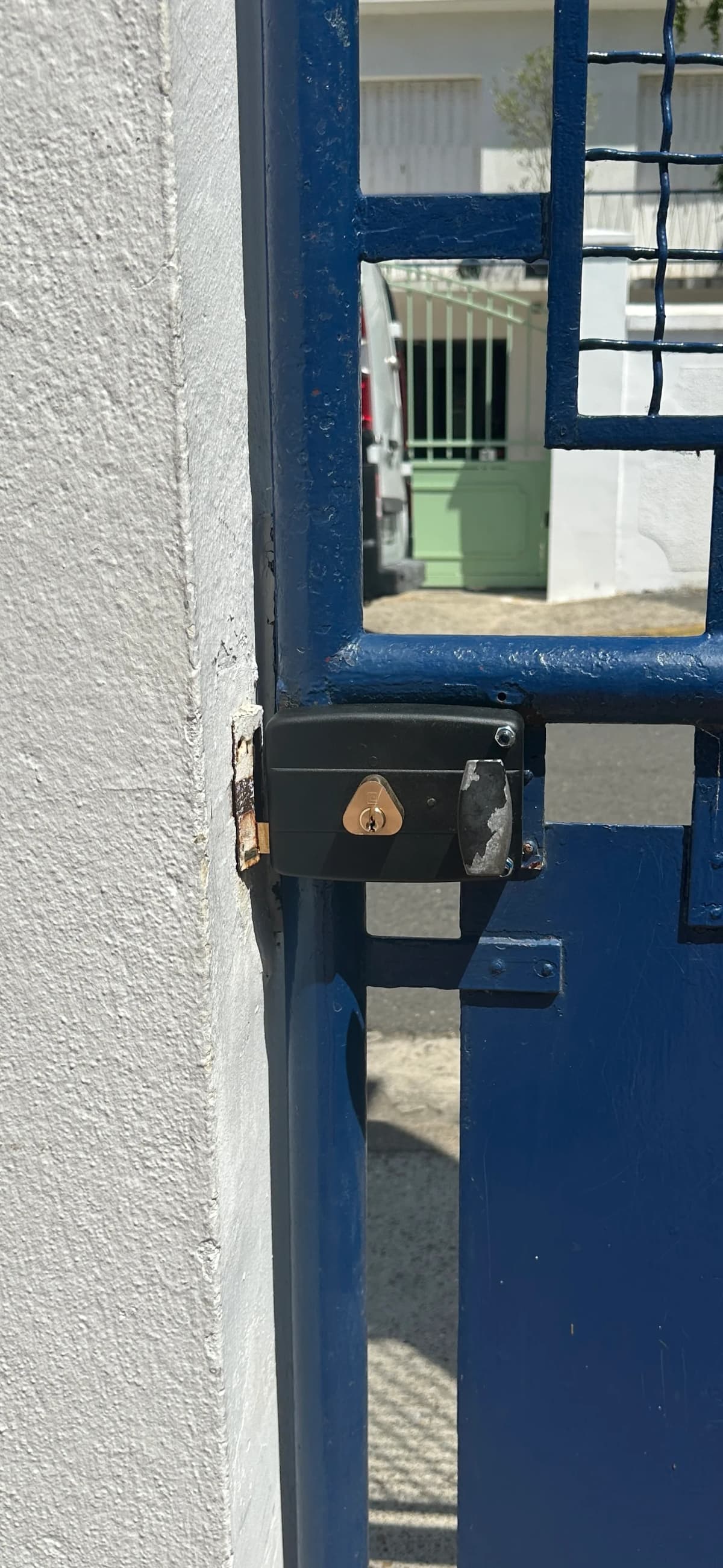 Serrure en applique noire posée sur portail métallique bleu à Paris
